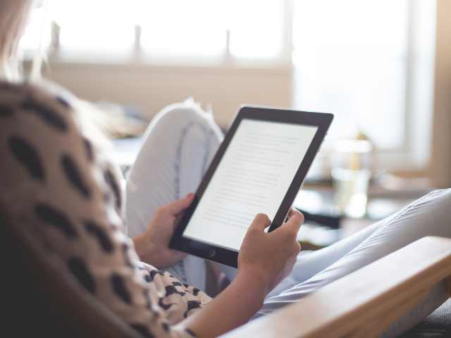 mulher sentada lendo no Kindle - O Kindle - se tornou uma excelente opção para manter a leitura em dia - divasforever.com.br